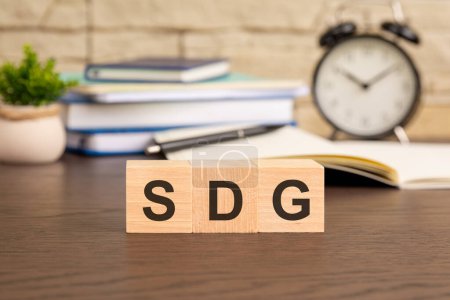 SDG-Symbol. Die Würfel, die vor dem Hintergrund eines Weckers das Wort "SDG" bilden, symbolisieren die Dringlichkeit und das Engagement zur Erreichung der Ziele nachhaltiger Entwicklung.