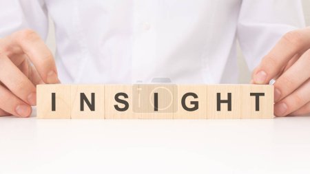 Photo for The image of a person holding wooden cubes with the text 'INSIGHT' symbolizes the process of unlocking valuable insights. concept unlocking insights - Royalty Free Image