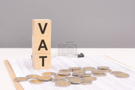 wooden blocks on a gray background with the text VAT - an abbreviation for Value Added Tax. strong business concept