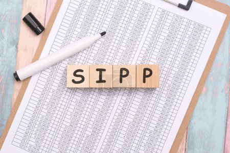 La composición de cubos de madera ortografía SIPP en la mesa de la oficina significa un enfoque estratégico en el empoderamiento de las personas en la gestión de sus ahorros para la jubilación.