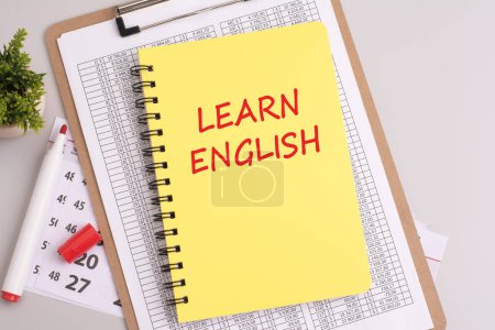 Foto de Texto 'Aprende inglés' escrito en una hoja amarilla de papel con un marcador rojo, capturado desde una vista superior. concepto de enseñanza de la comunicación internacional - Imagen libre de derechos