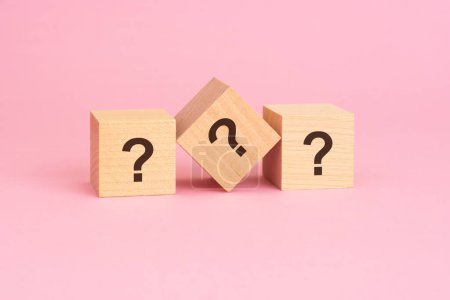 Téléchargez les photos : La question symbole sur cubes en bois sur un fond rose transmet un concept de suggère enquête, curiosité, résolution de problèmes, et la recherche de réponses - en image libre de droit