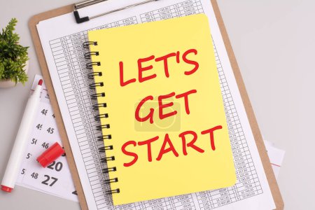 readiness and enthusiasm to begin an activity or project, illustrated by the handwritten message 'LET'S GET STARTED' on a yellow sheet of paper with a red marker, captured from a top-down perspective