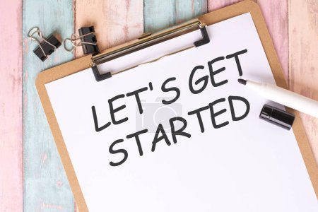 The handwritten text 'LET'S GET STARTED' on a white sheet of paper from a top view suggests a motivational tone, encouraging action and initiative
