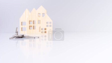 clés de maison en gros plan, avec des modèles de maison flous en arrière-plan et mise au point sélective. transmet un concept immobilier