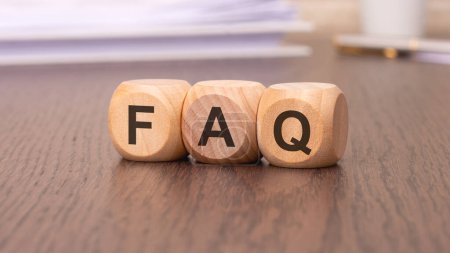 Téléchargez les photos : Texte 'FAQ - Foire Aux Questions' sur les cubes en bois, fond brun - en image libre de droit