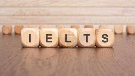 the text ielts is written on wooden blocks on a light background