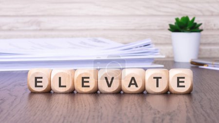 Holzklötze mit dem Wort "ELEVATE" stehen für ein Konzept des Fortschritts, der Verbesserung und des Aufstiegs hin zu mehr Leistung und Exzellenz.