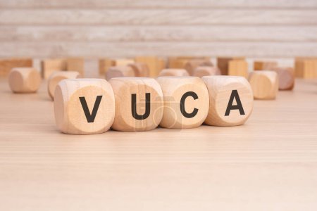 acronym VUCA on a wooden cubes with wooden background. copy space concept. selection focus