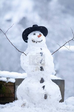 Glücklicher Schneemann im Winter bauen mit Kindern