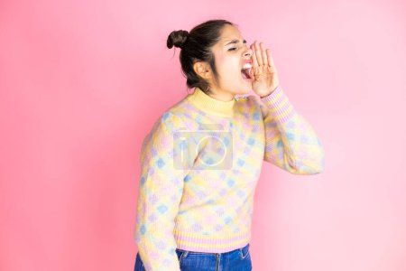 Photo for Young beautiful woman wearing casual sweater over isolated pink background shouting and screaming loud to side with hand on mouth - Royalty Free Image