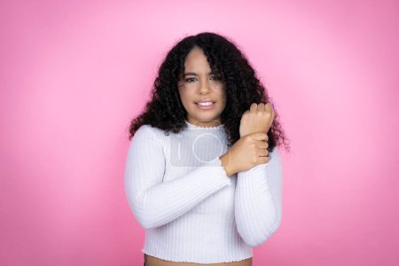 African american woman wearing casual sweater over pink background suffering pain on hands and fingers, arthritis inflammation