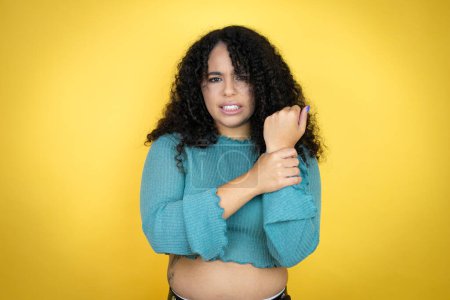 Photo for African american woman wearing casual sweater over yellow background suffering pain on hands and fingers, arthritis inflammation - Royalty Free Image