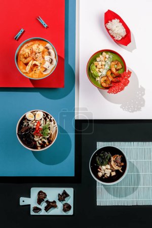Téléchargez les photos : Composition avec variété de soupe asiatique sur fond coloré, fruits de mer, tom yum, ramen, soupe à la crème aux épinards et aux crevettes, soupe miso, saumon, champignons. - en image libre de droit