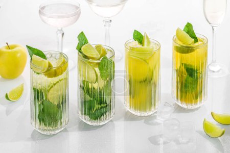 Téléchargez les photos : Classic cocktail mix mohito in glass on white background with lime, lemon, mint, soda,  alcohol. - en image libre de droit