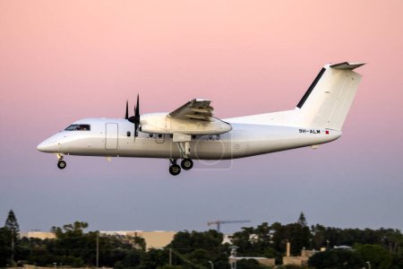 Photo for Luqa, Malta - December 1, 2022: Air CM Global De Havilland Canada DHC-8-103 Dash 8 (REG: 9H-ALM) arriving after sunset from Libya. - Royalty Free Image