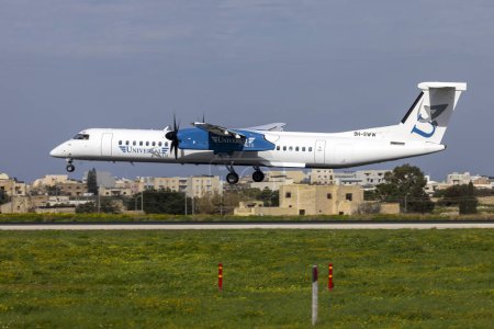 Foto de Luqa, Malta - 7 de febrero de 2024: Universal Air Bombardier DHC-8-402 Q400 (Reg. : 9H-SWW) llegando desde Sicilia, Italia. - Imagen libre de derechos