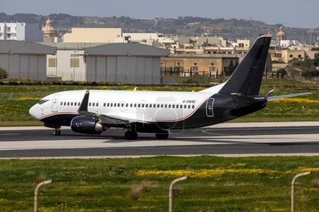 Photo for Luqa, Malta - March 8, 2024: 2Excel Aviation Boeing 737-3L9 (Reg: G-SWRD) departing runway 31 after 2 days in Malta. - Royalty Free Image
