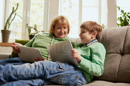 Foto de Uso de tabletas digitales. Feliz abuela y nieto pasar tiempo juntos en casa. Concepto de emociones, familia, felicidad, cuidado, apoyo y actividades de ocio - Imagen libre de derechos