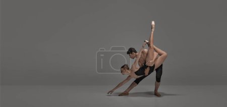 Photo for Young man and woman, ballet dancers performing on stage isolated over dark grey studio background. FLyer. Concept of classical dance aesthetics, choreography, art, beauty. Copy space for ad - Royalty Free Image