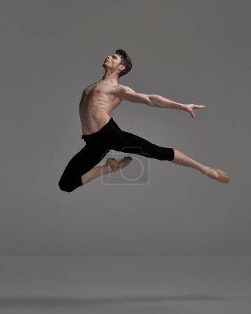 Photo for Portrait of young muscular man, ballet dancer performing isolated over dark grey studio background. Flying high. Concept of classical dance aesthetics, choreography, art, beauty. Copy space for ad - Royalty Free Image