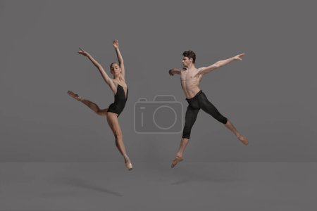Photo for Young man and woman, ballet dancers performing isolated over dark grey studio background. Expressing talent. Concept of classical dance aesthetics, choreography, art, beauty. Copy space for ad - Royalty Free Image