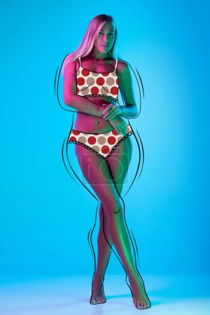 Photo for Remain feminine. Young girl with perfect body shape in underwear isolated over blue background. Drawings of overweight lines around body. Before and after, weight loss and wellness concept - Royalty Free Image