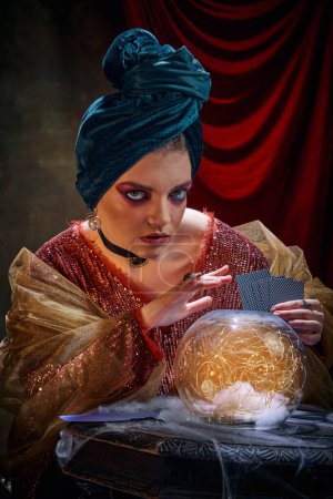 Photo for Mysticism. Portrait of beautiful mysterious female soothsayer and molfarka guesses and predicts fate. Retro circus, mysticism and witchcraft. Concept of art, creativity and inspiration. - Royalty Free Image