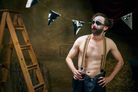 Photo for Addiction. Conceptual portrait of sad male clown going through a personal tragedy, despair in the old retro circus backstage. Concept of fate, job, emotions, facial expression, mental health. - Royalty Free Image