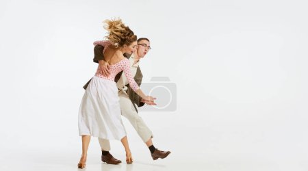 Retrato dinámico de bailarines felices, elegantes y enérgicos bailando lindy hop o swing aislados sobre fondo blanco. Concepto de música, energía, felicidad, humor, acción, estilo