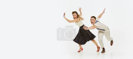 Téléchargez les photos : Portrait dynamique de danseurs heureux, élégants et énergiques dansant lindy hop ou swing danse isolé sur fond blanc. Concept de musique, énergie, bonheur, humeur, action, style - en image libre de droit