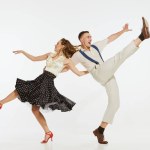 Love in motion. Young excited man and woman wearing 60s american fashion style clothes dancing retro dance isolated on white background. Music, energy, happiness, mood, action
