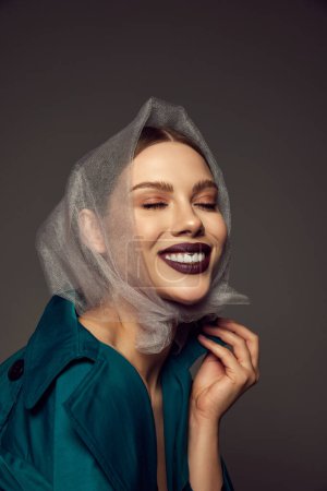 Photo for Happy young beautiful woman with artistic makeup laughing with closed eyes over grey background. Autumn fashion collection. Style, beauty, high fashion, magazine style and ad - Royalty Free Image