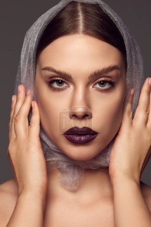 Photo for Serious look. Close-up portrait of glamorous female fashion model with artistic makeup expressing emotions over grey background. Style, beauty, high fashion, magazine style and ad - Royalty Free Image