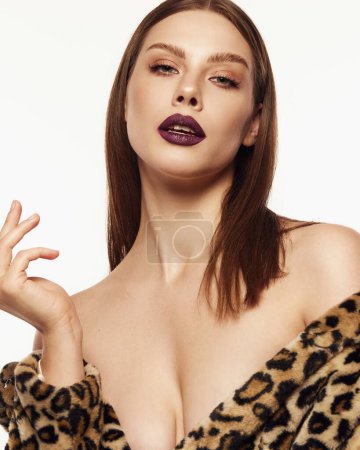 Photo for Portrait of beautiful woman posing in animal print coat with dark lips makeup look over white background. Party look, modern fashion. Concept of style, beauty, high fashion, magazine style and ad - Royalty Free Image