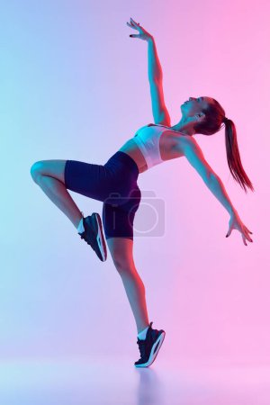Photo for Portrait of young sportive woman training, doing full body exercises isolated over gradient blue pink background in neon light. Concept of sport, strength, body care, fitness, wellbeing, health. Ad - Royalty Free Image