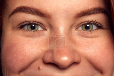 Photo for Smiling look. Mimics. Close-up image of green-brown female eyes looking at camera. Emotions. Concept of vision, contact lenses, eyebrow makeup, health, medical care. Poster, ad - Royalty Free Image