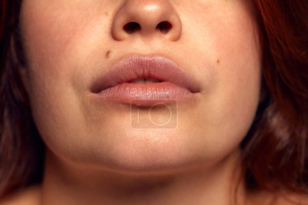 Téléchargez les photos : Vue rapprochée de la bouche de forme parfaite féminine avec du rouge à lèvres de couleur nue. Soin hydratant. Injections cosmétologiques. Putain. Concept de beauté naturelle, cosmétiques, émotions, augmentation des lèvres - en image libre de droit