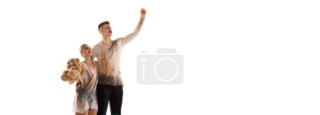 Foto de Ganar. Retrato de hombre y mujer jóvenes, deportistas de patinaje artístico posando aislados sobre fondo blanco. Volador. Concepto de movimiento, deporte, belleza, hobby, competición, danza, coreografía. Copiar espacio para anuncio - Imagen libre de derechos