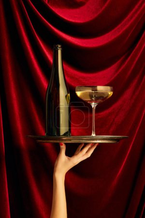 Photo for Traditional luxury taste. Bottle and glass with champagne over dark red silk background. Valentines Day celebration. Concept of holiday, party, drink. Complementary colors. Copy space for ad. Pop art - Royalty Free Image