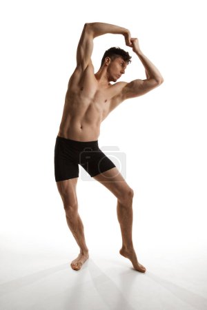 Foto de Hombre guapo maduro posando sin camisa en boxeadores negros sobre fondo de estudio blanco. Estética muscular, corporal en relieve. Concepto de salud y belleza de los hombres, cuidado del cuerpo y la piel, fitness. Arte corporal - Imagen libre de derechos
