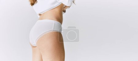 Foto de Cropped image of female body, buttocks in underwear posing over grey studio background. Anti-cellulite care. Banner. Concept of body and skin care, fitness, natural beauty, health, wellness. - Imagen libre de derechos
