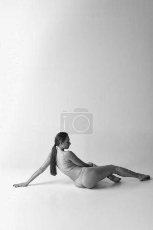 Foto de Black and white photography. Back view photo of tender, slim woman posing in underwear. Body aesthetics. Concept of body and skin care, fitness, natural beauty, health, wellness. - Imagen libre de derechos