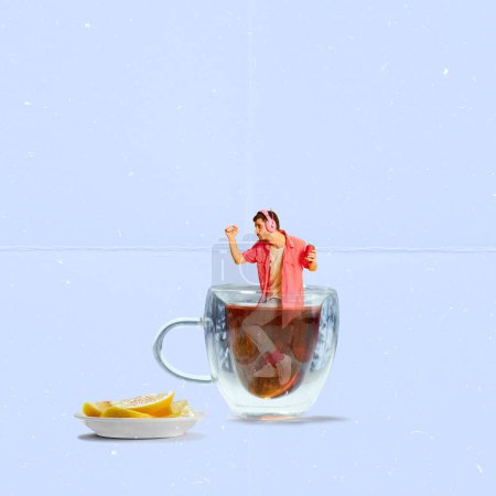 Foto de Contemporary art collage. Creative design. Stylish, cheerful young man in pink clothes dancing inside cup with black tea with lemons. Concept of hot drinks, coziness, taste, emotions, lifestyle - Imagen libre de derechos