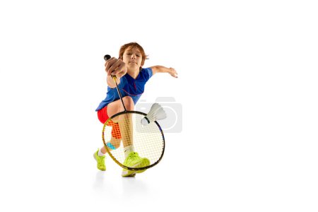 Photo for Portrait of teen boy in uniform playing badminton, hitting shuttlecock with racket isolated over white background. Goal. Concept of sportive lifestyle, motion, action, competition, hobby - Royalty Free Image