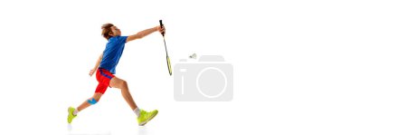 Photo for Portrait of teen boy in uniform playing badminton, hitting shuttlecock with racket isolated over white background. Concept of sportive lifestyle, motion, action, competition. Copy space for ad, banner - Royalty Free Image