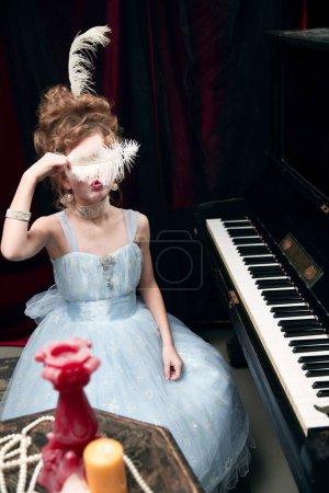 Photo for Portrait of cute little girl, child in image of medieval royal person sitting at the piano and posing in amazing dress. Concept of historical remake, comparison of eras, medieval fashion, childhood - Royalty Free Image