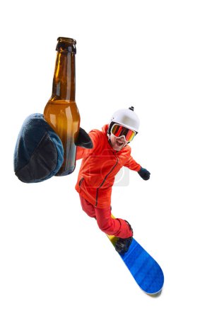 Photo for Portrait of active man, snowboarder in uniform riding on snowboard and holding beer isolated over white studio background. Concept of winter sport, action, motion, hobby, leisure time - Royalty Free Image