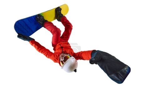 Téléchargez les photos : Upside Down trick. Portrait of active man, snowboarder in uniform riding on snowboard isolated over white studio background. Concept of winter sport, action, motion, hobby, leisure time - en image libre de droit