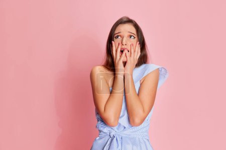 Foto de Feeling nervous. Portrait of young emotive girl posing with shocked face over pink studio background. Concept of youth, beauty, fashion, lifestyle, emotions, facial expression. Ad - Imagen libre de derechos